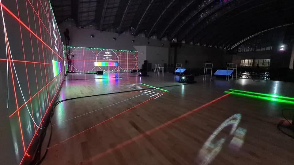Uno spazio interno ben illuminato con griglie e linee proiettate su una parete e sul pavimento; una configurazione di prova.
