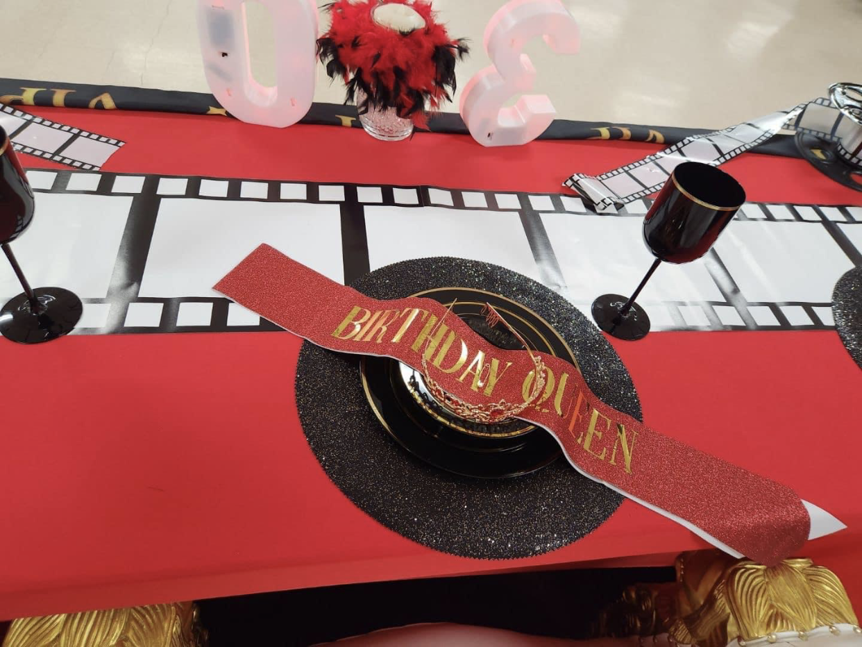 A red table decorated for a birthday celebration with 