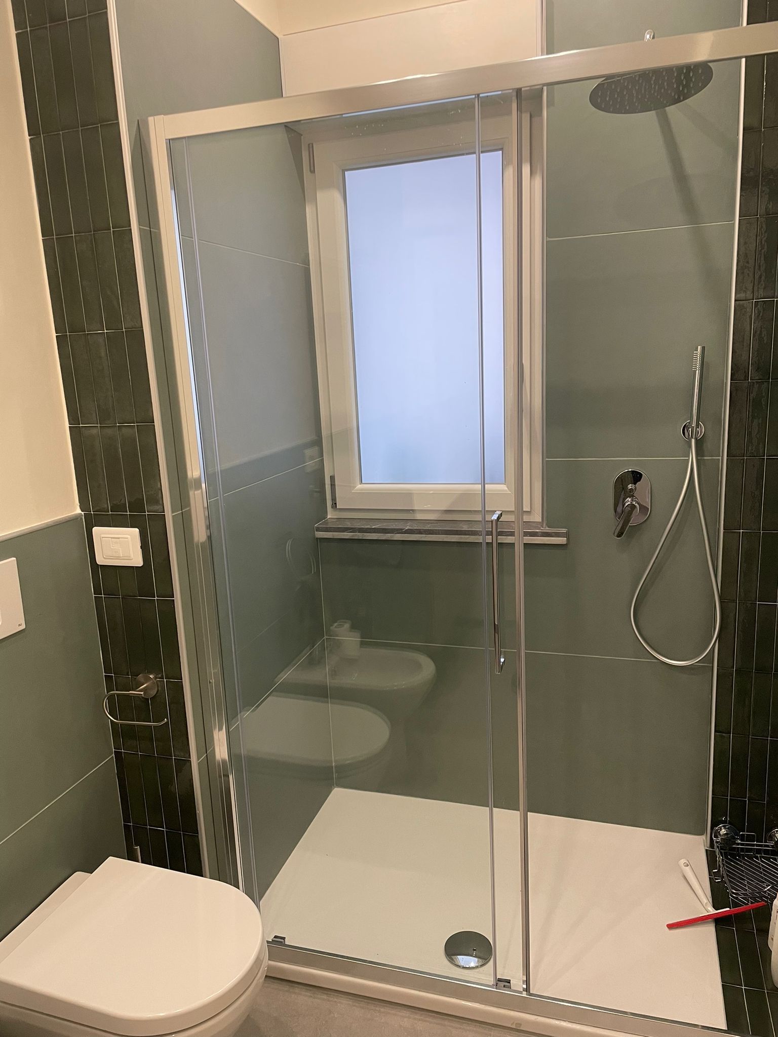 Un bagno con doccia, wc e finestra.