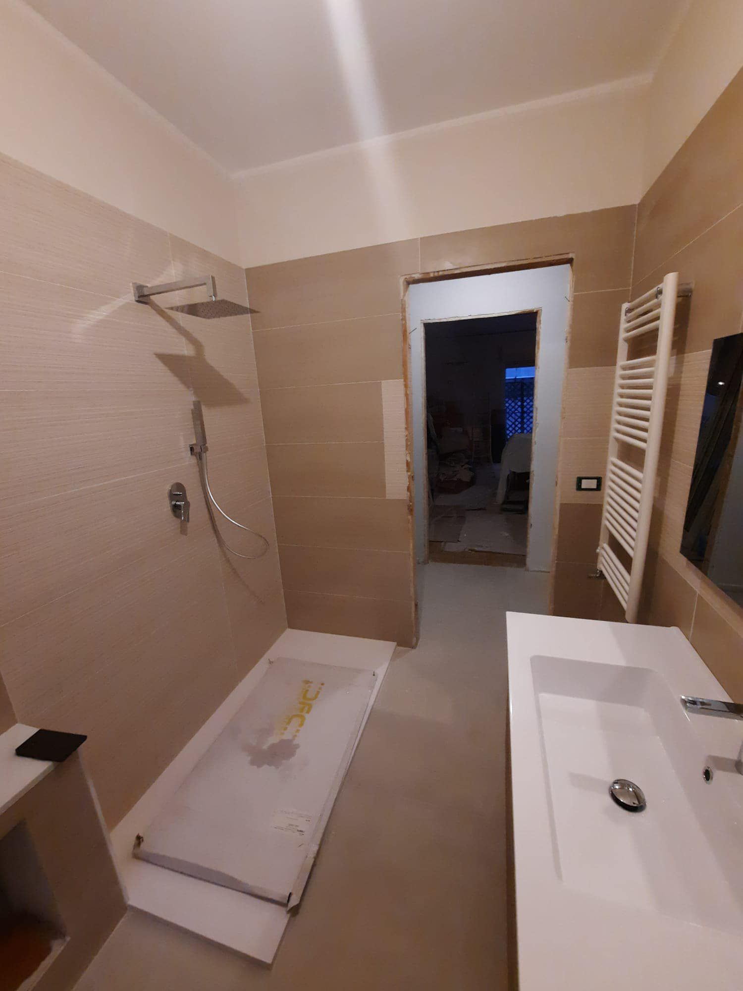 Un bagno con lavandino, doccia e specchio.