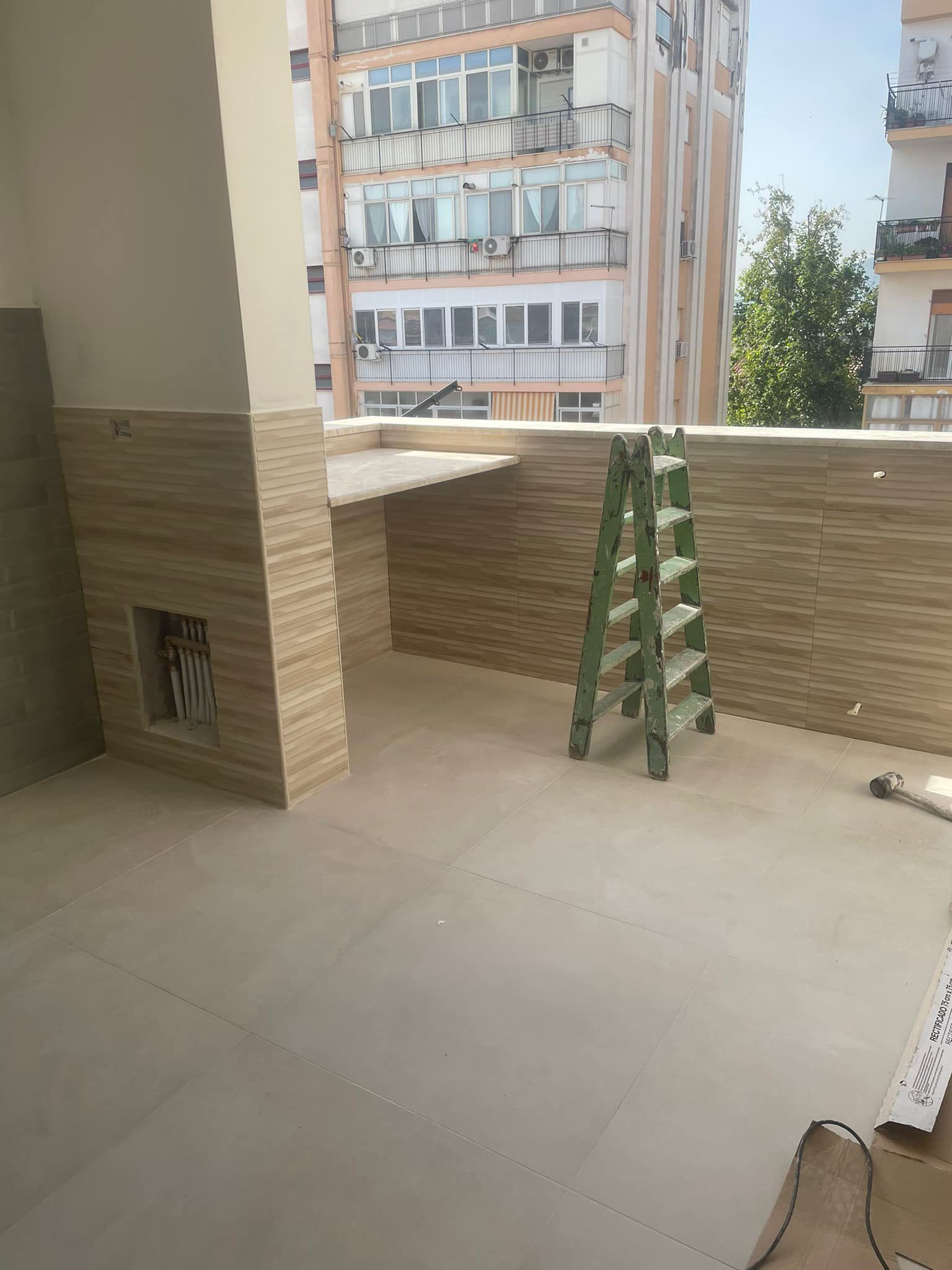 Una scala è appoggiata su un balcone accanto a un edificio.
