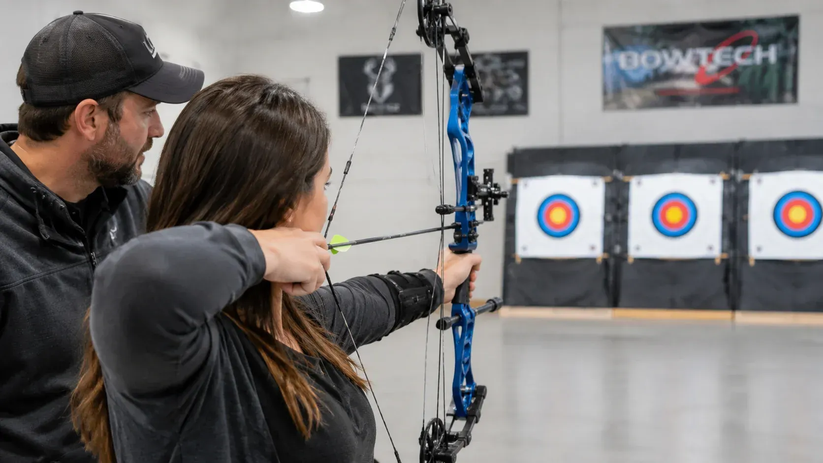 Instructor helping beginner learn How Much Do Archery Lessons Cost for Beginners?