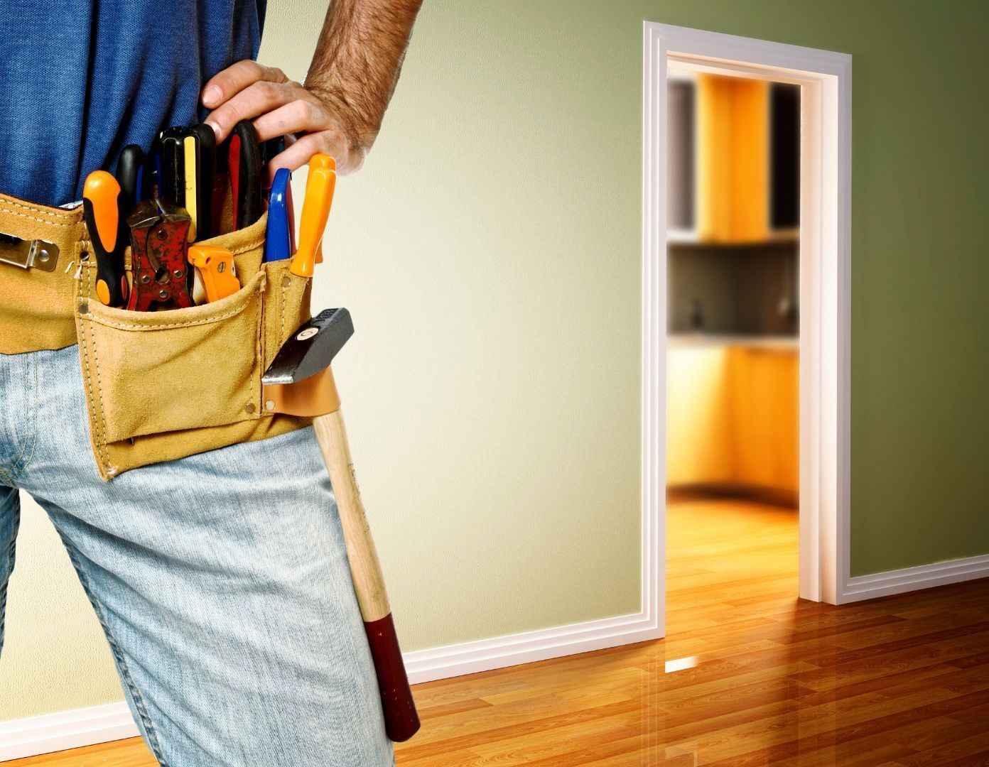 A man is wearing a tool belt and holding a hammer.
