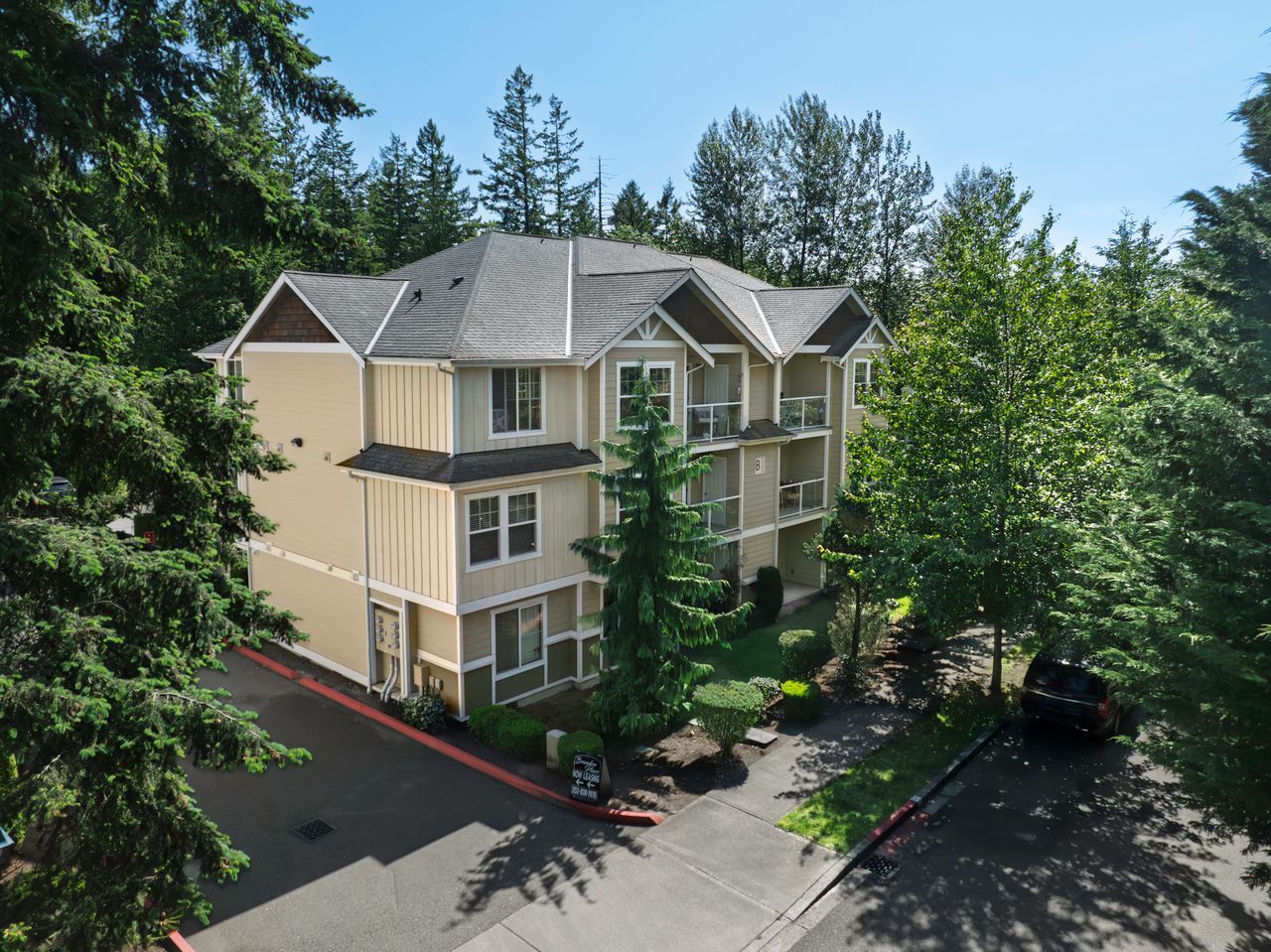 Photo of a building seen from the third story level, the building is surrounded by trees
