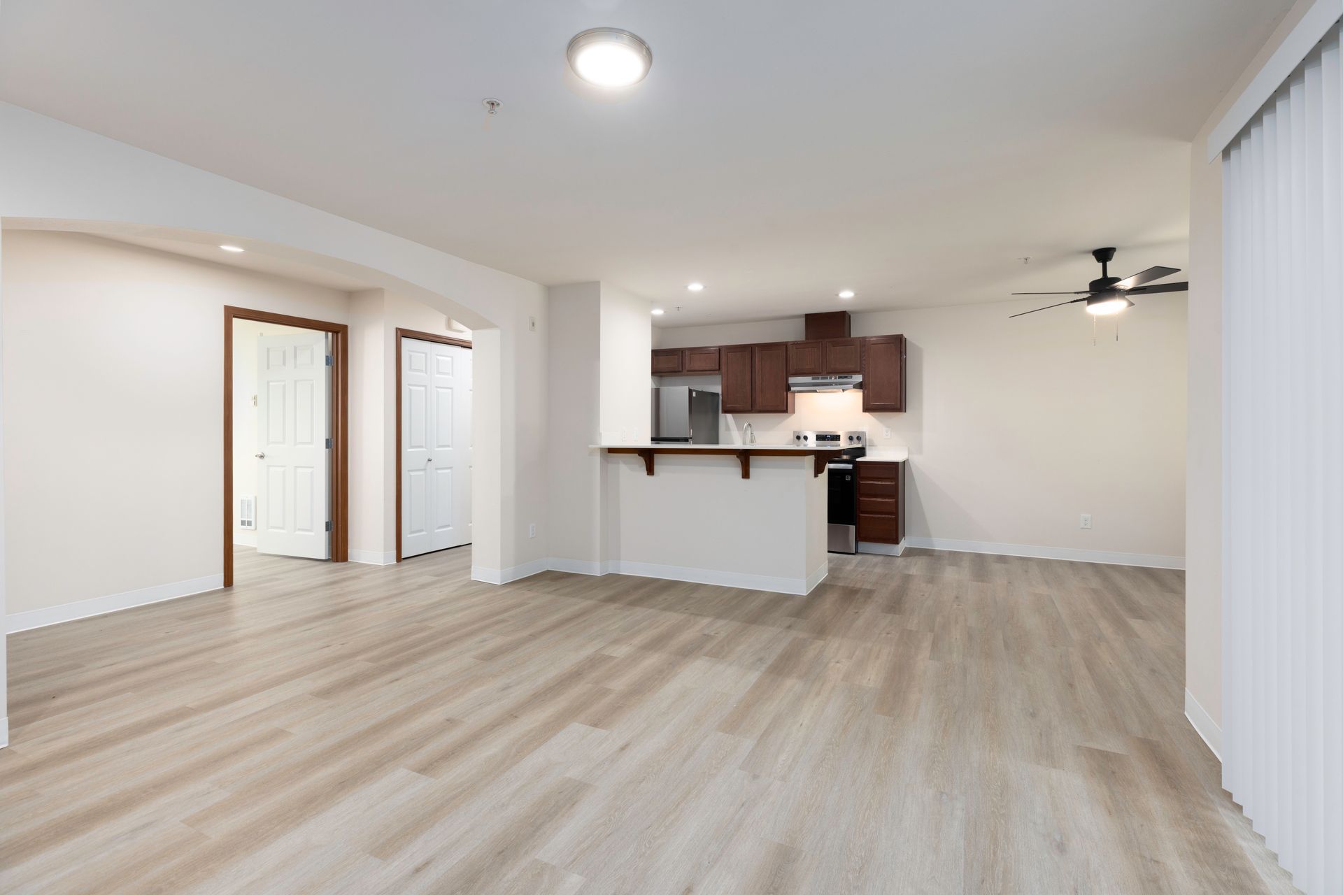 Photo of a living room with a kitchen in the background