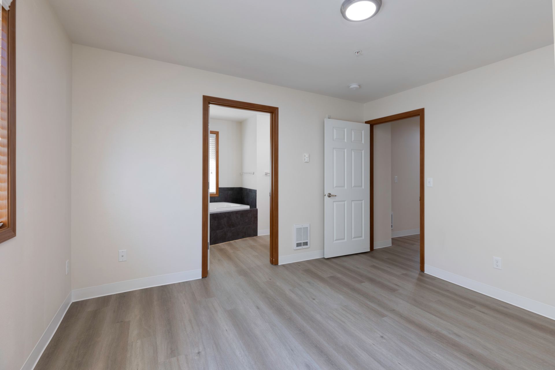 Photo of a master bedroom with the bathroom in the background