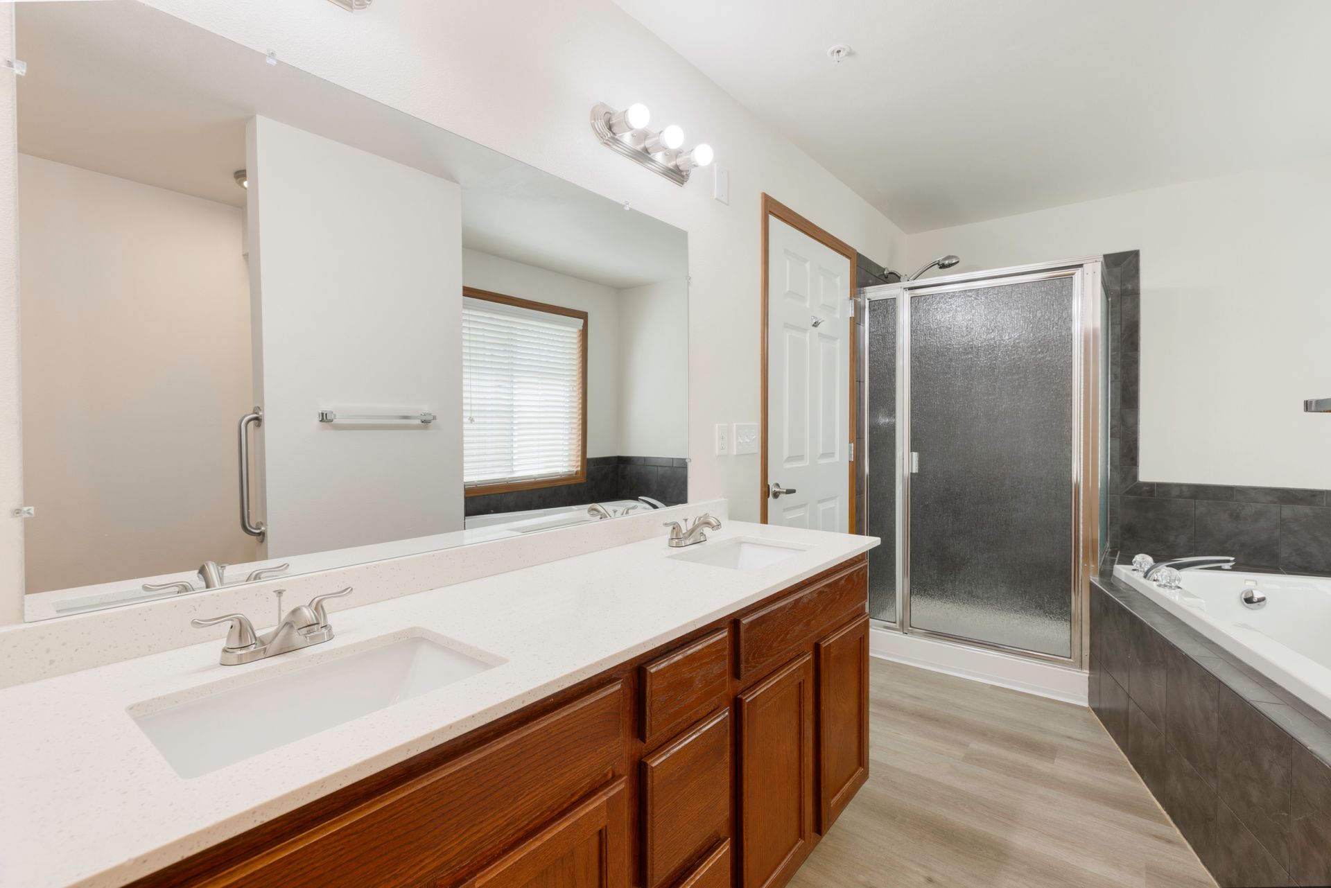 Photo of a large, spa-style bathroom with dual vanity sink, a soak-in tub, and a stall-style shower
