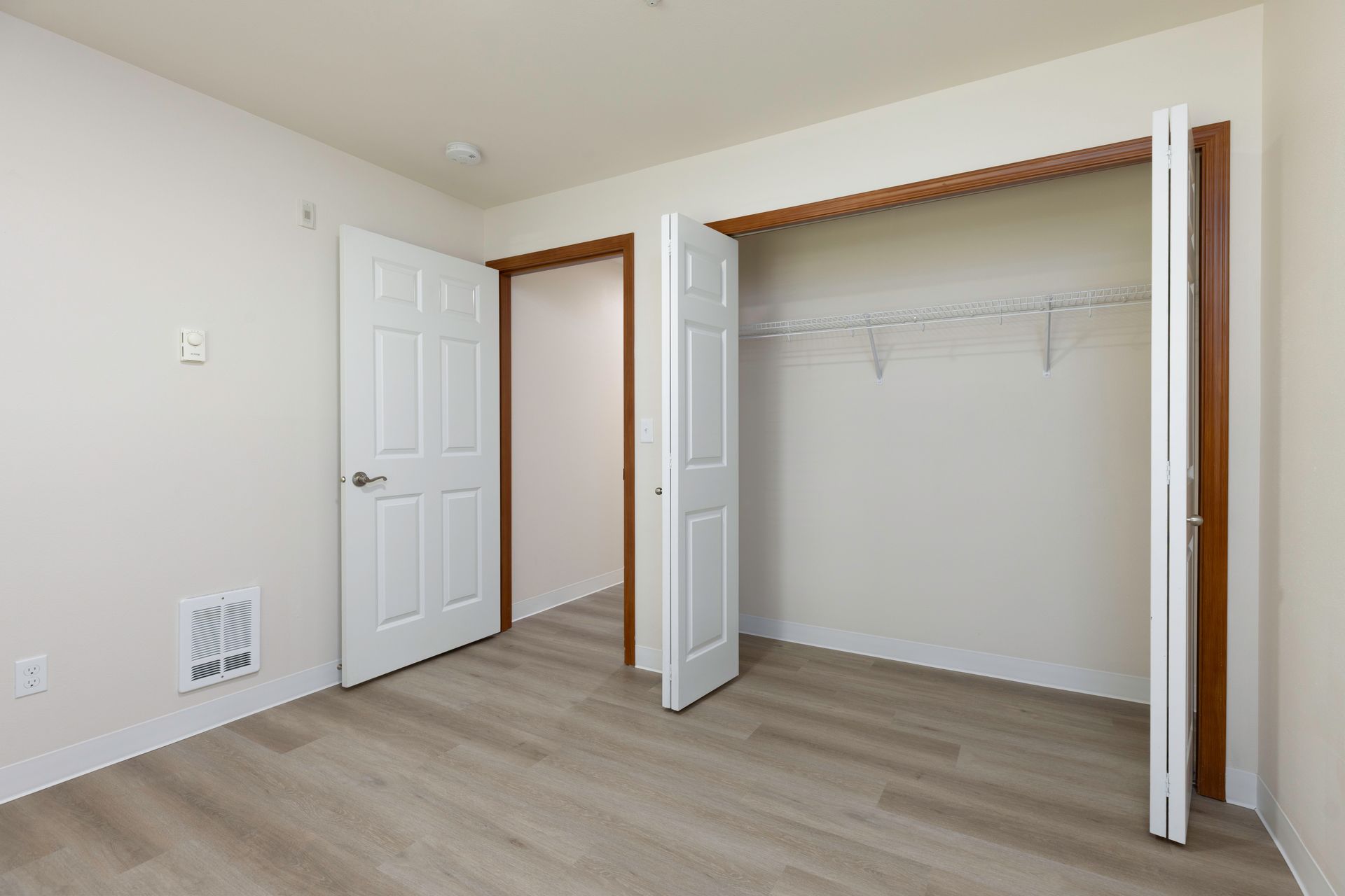 Photo of a bedroom with open closet doors