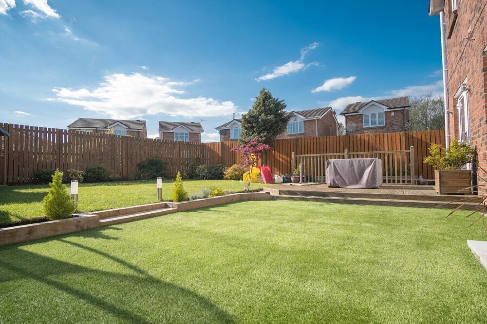 A Backyard With A Lush Green Lawn And A Wooden Fence — Baker & Co. Landscape Construction In Gulliver, QLD