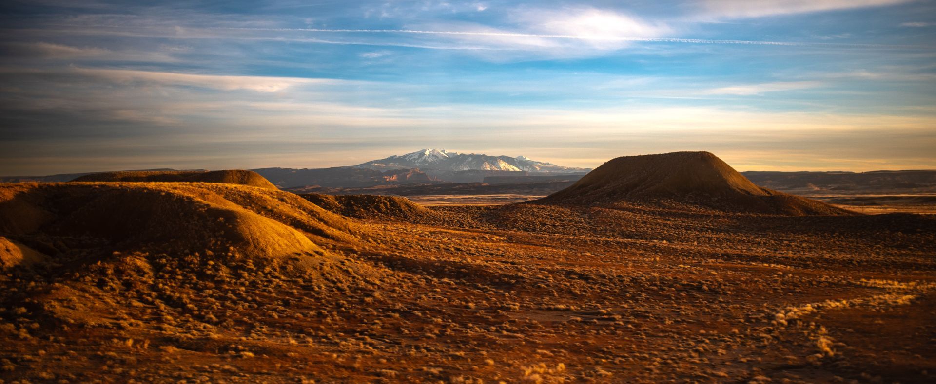 Scenic view of snowcapped mountains across desert taken from Amtrack car