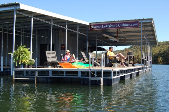 A couple sits on a dock with a sign that says peace lakeview cabin