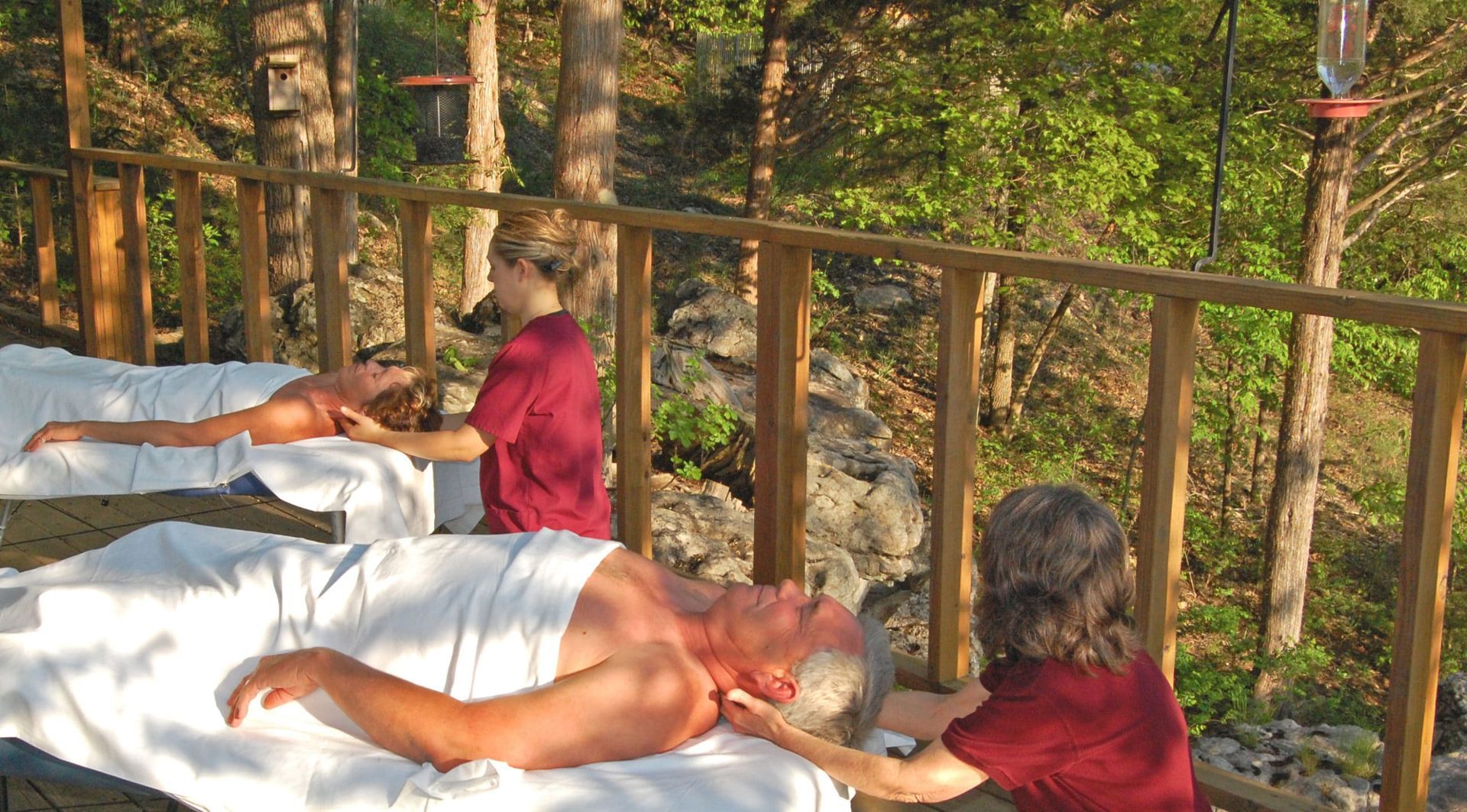 A man is laying on a table getting a massage from a woman
