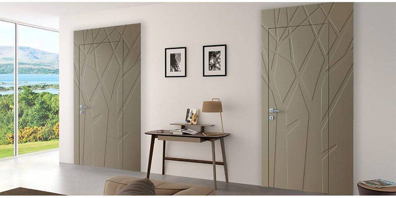 Stanza minimalista con due porte beige, una piccola scrivania, opere d'arte alle pareti e una finestra luminosa con vista panoramica.