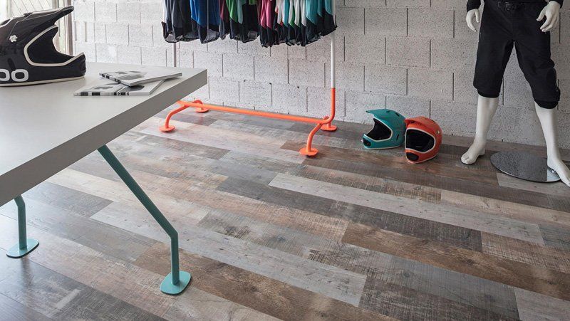 Stanza interna con tavolo da ping-pong, appendiabiti e sbarre arancioni per esercizi su un pavimento in legno.