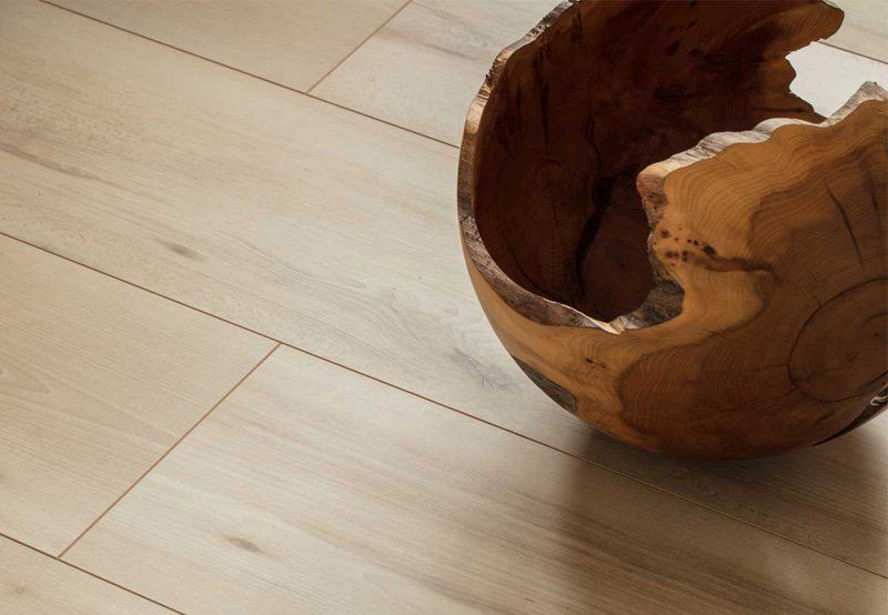 Ciotola di legno su un pavimento di legno chiaro con un'apertura rotta e frastagliata