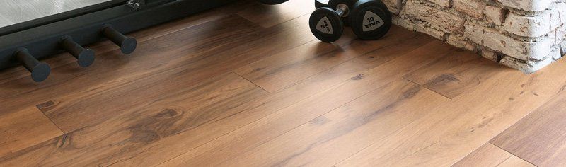 Pavimento in legno accanto al focolare del camino con manubri neri e angolo del muro di mattoni