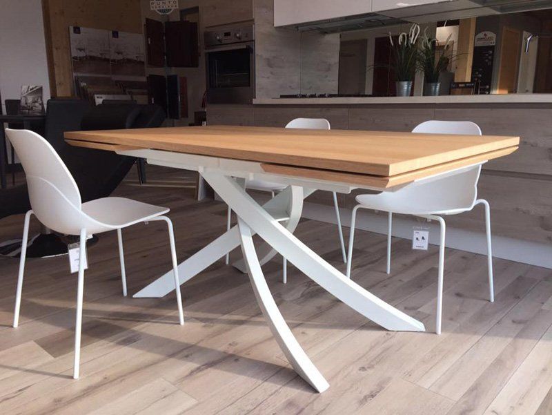 Tavolo da pranzo moderno con sedie bianche in una stanza luminosa