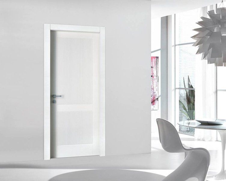 Porta interna bianca con pannello in vetro satinato in una luminosa stanza moderna
