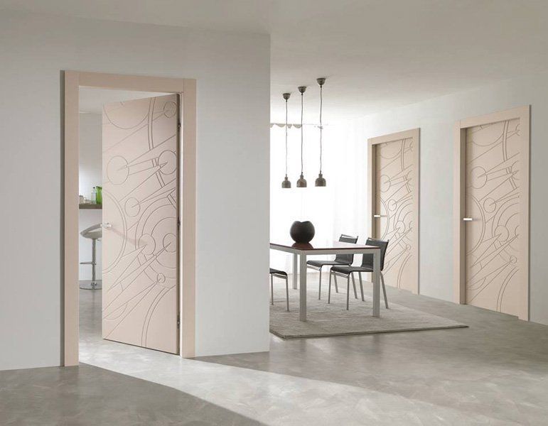 Zona pranzo minimalista a pianta aperta con porte scorrevoli in vetro satinato, tavolo, sedie e lampade a sospensione.