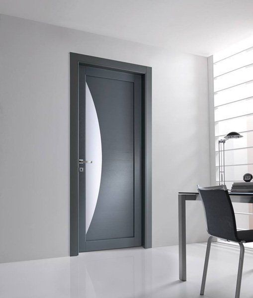 Interno moderno sui toni del grigio, con una porta chiusa accanto a un tavolo da pranzo con sedia, vicino a una finestra luminosa.