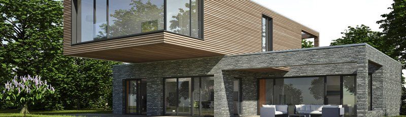 Casa moderna a due piani con ampio balcone vetrato e facciata in pietra, immersa nel verde.