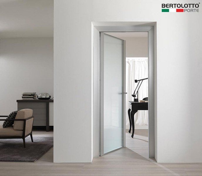 Interno moderno di colore bianco con una porta a vetri aperta che conduce a una stanza con attrezzature per l'esercizio fisico.