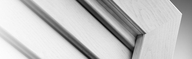 Lamelle architettoniche bianche e grigie con linee diagonali nette su uno sfondo chiaro