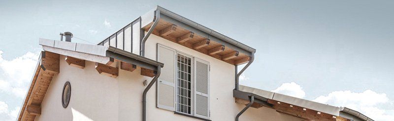 Tetto bianco con abbaini contro un cielo azzurro