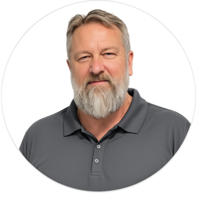 Portrait of a bearded man in a gray polo shirt against a white background