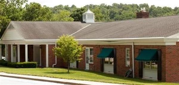 A brick building with green awnings on the windows