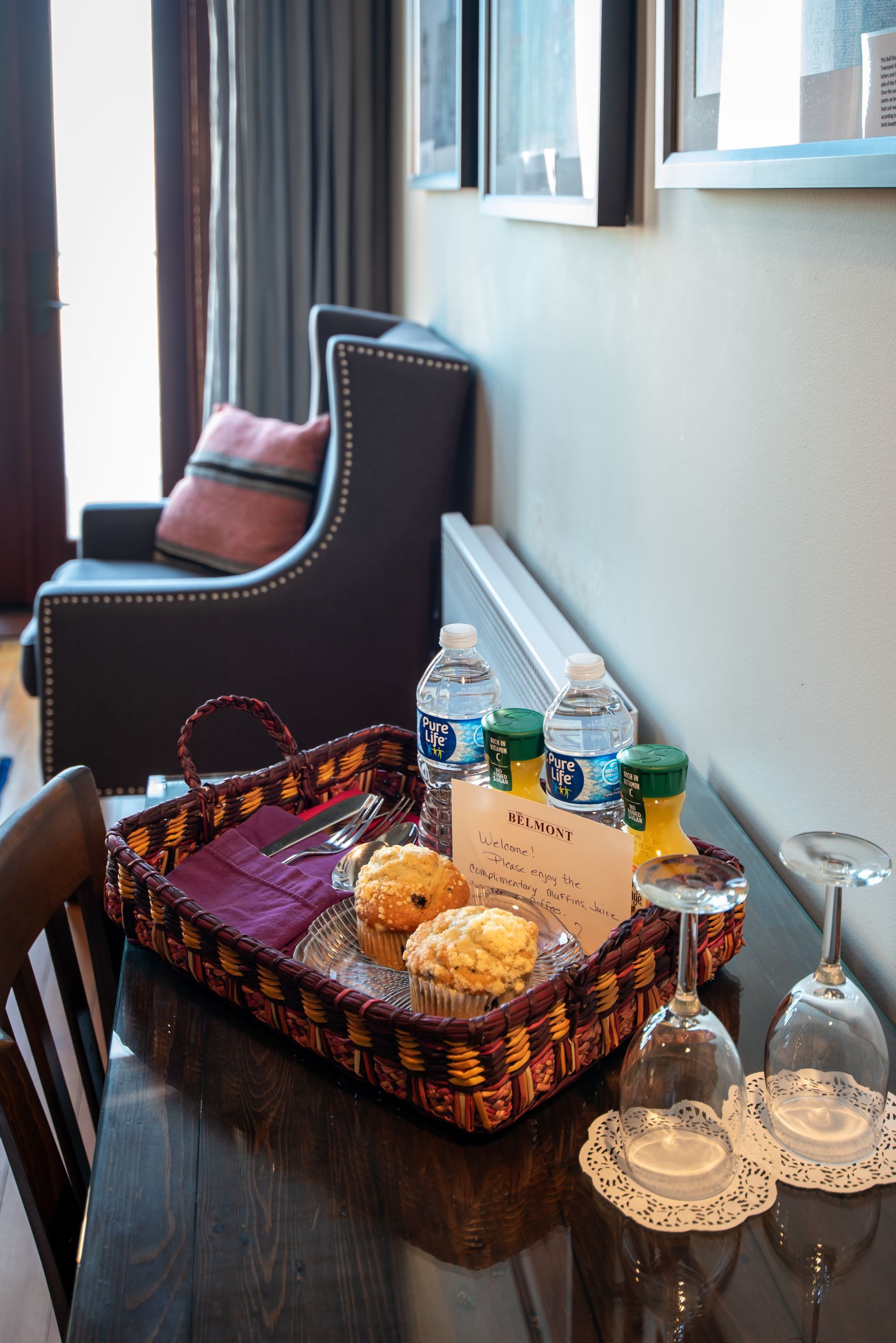 A tray of food and wine glasses on a table in a hotel room.