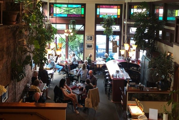 A restaurant with tables and chairs and a clock on the wall