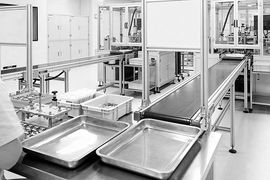 Close-up of a CNC machine bed with a grid of circular indentations and a linear rail mechanism with a mounting plate.