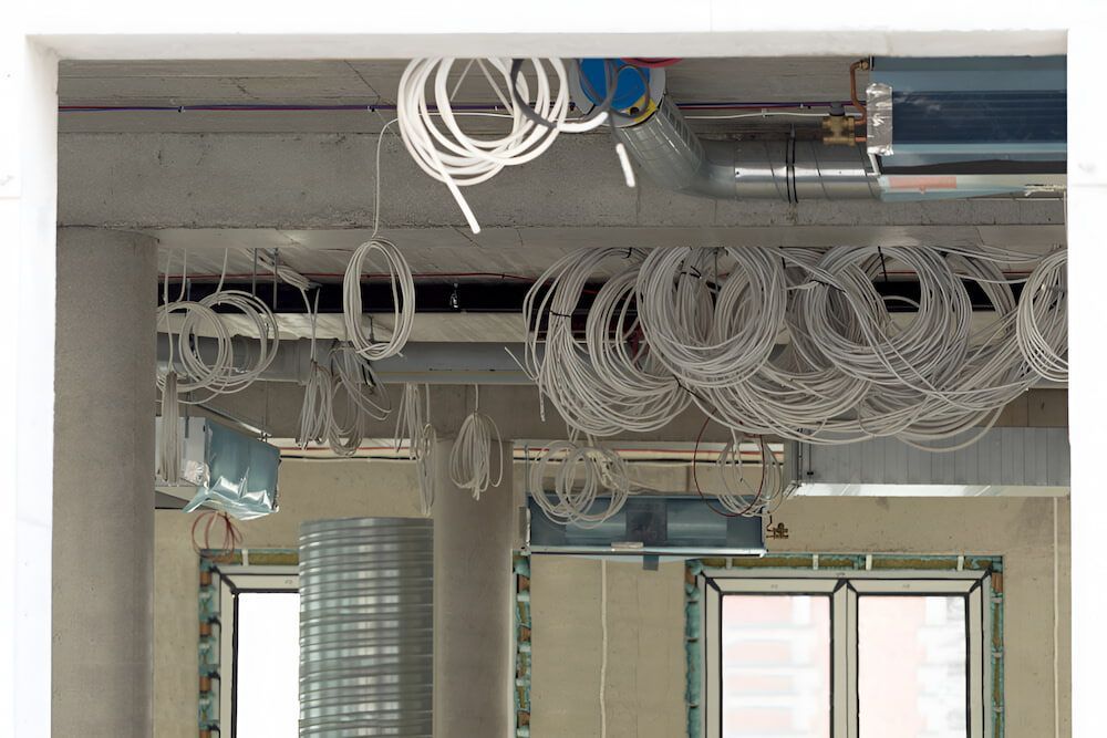 A Room With A Lot Of Wires Hanging From The Ceiling — Homeland Electrical & Refrigeration In Braitling, NT