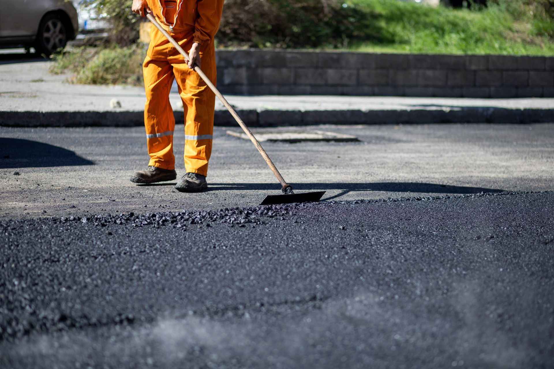 A worker applying sealant to an asphalt driveway, demonstrating expert driveway paving services. A worker applying sealant to an asphalt driveway, demonstrating expert driveway paving services.