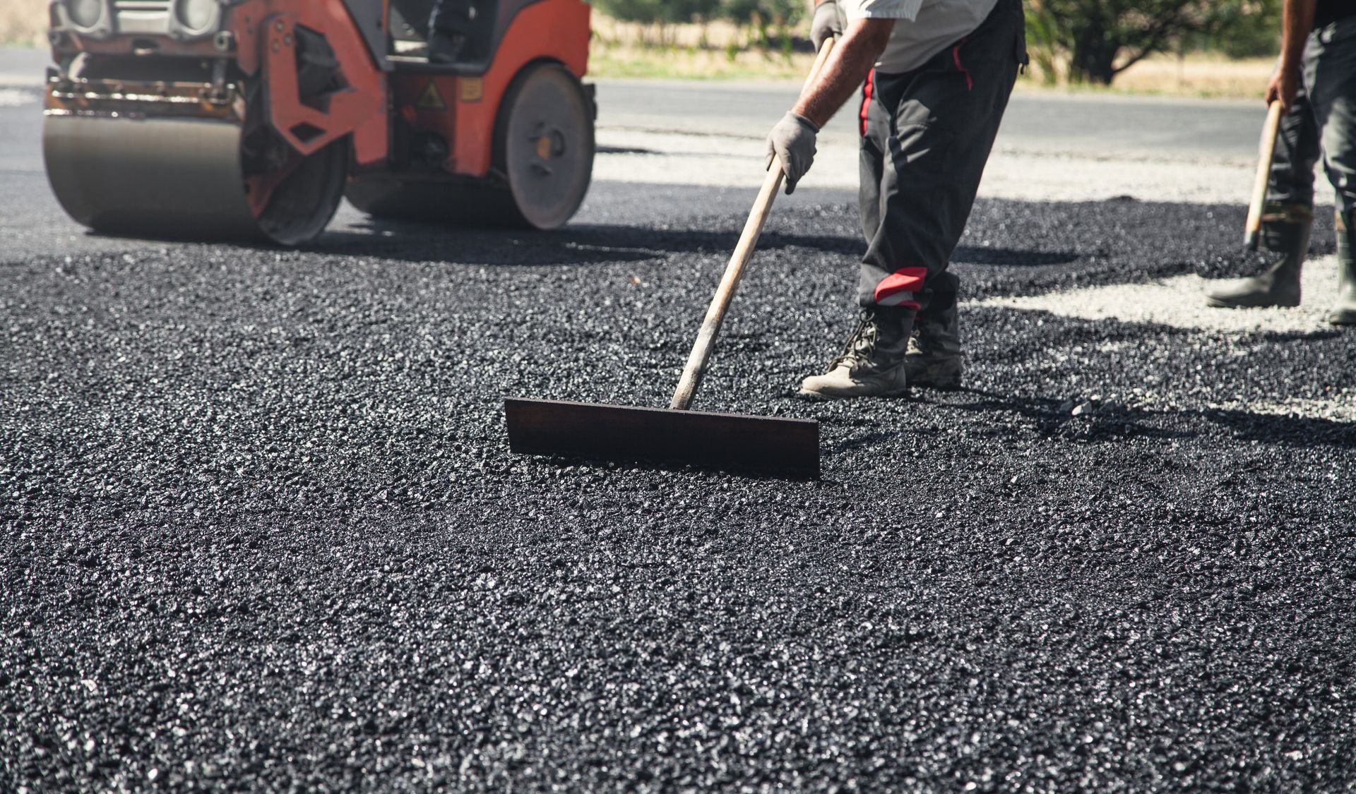 Commercial paving contractor crew resurfacing a commercial parking lot.