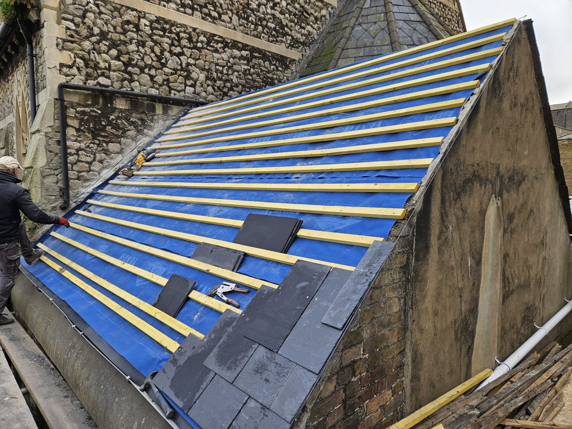 A man is working on the roof of a building.