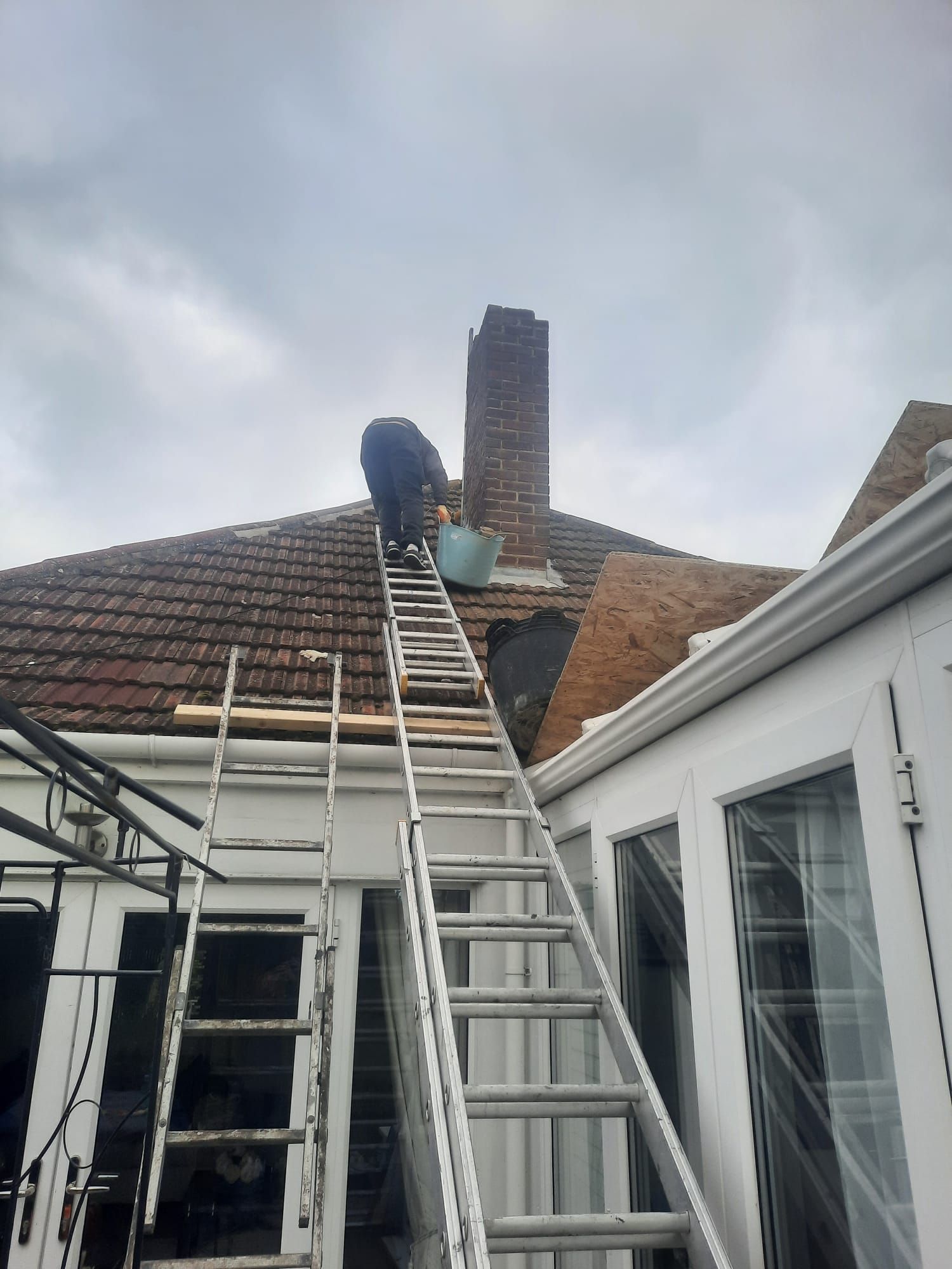 a man is working on the roof of a house with a ladder