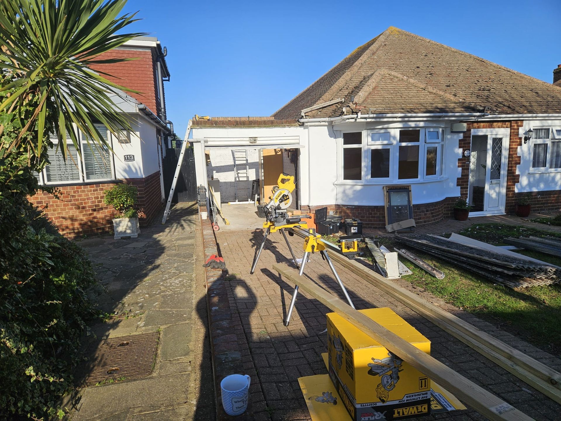 A house is being remodeled and a saw is sitting in front of it.