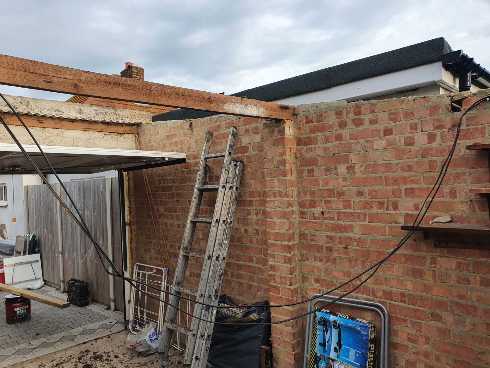 a ladder is leaning against a brick wall next to a garage door .