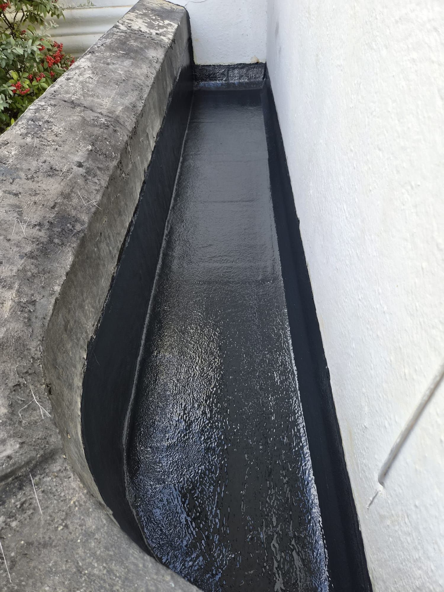 Completed black GRP fibreglass roof channel with a high upstand against the house wall in Percy Avenue, Broadstairs