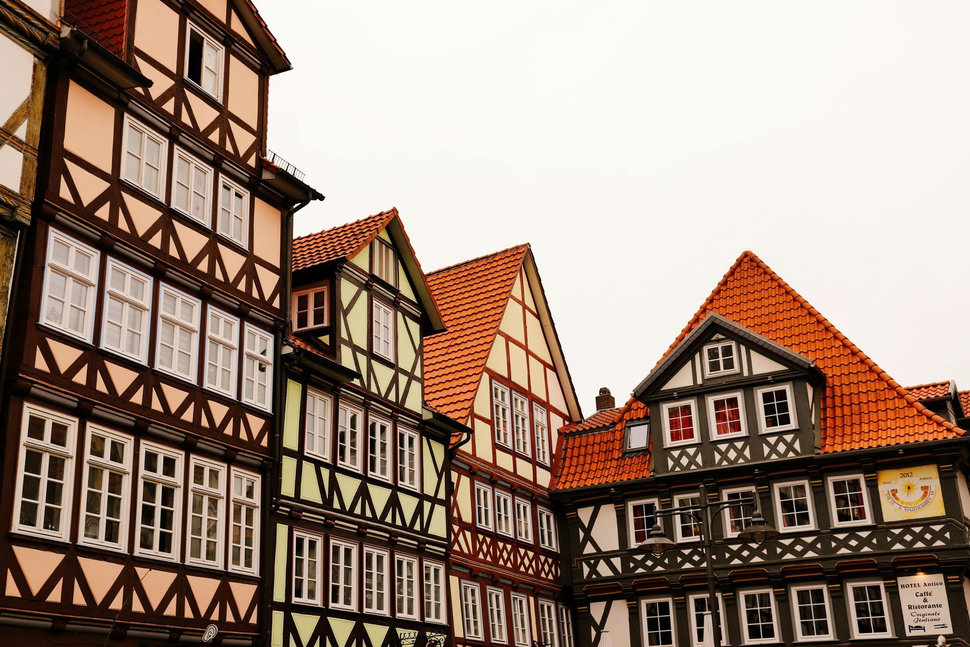 A row of half timbered buildings with red tiled roofs.