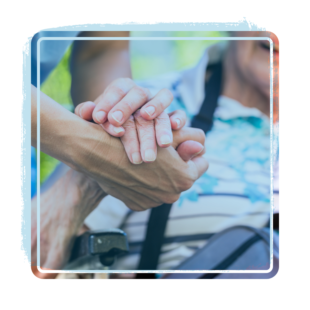 A person is holding another person 's hand in a wheelchair.