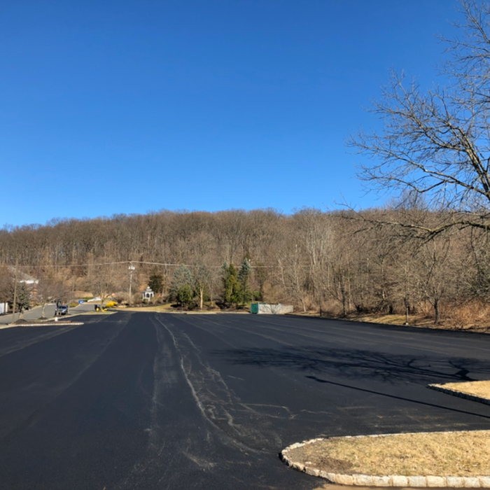 Yellow striped pavement markings on asphalt, likely a crosswalk or caution area.