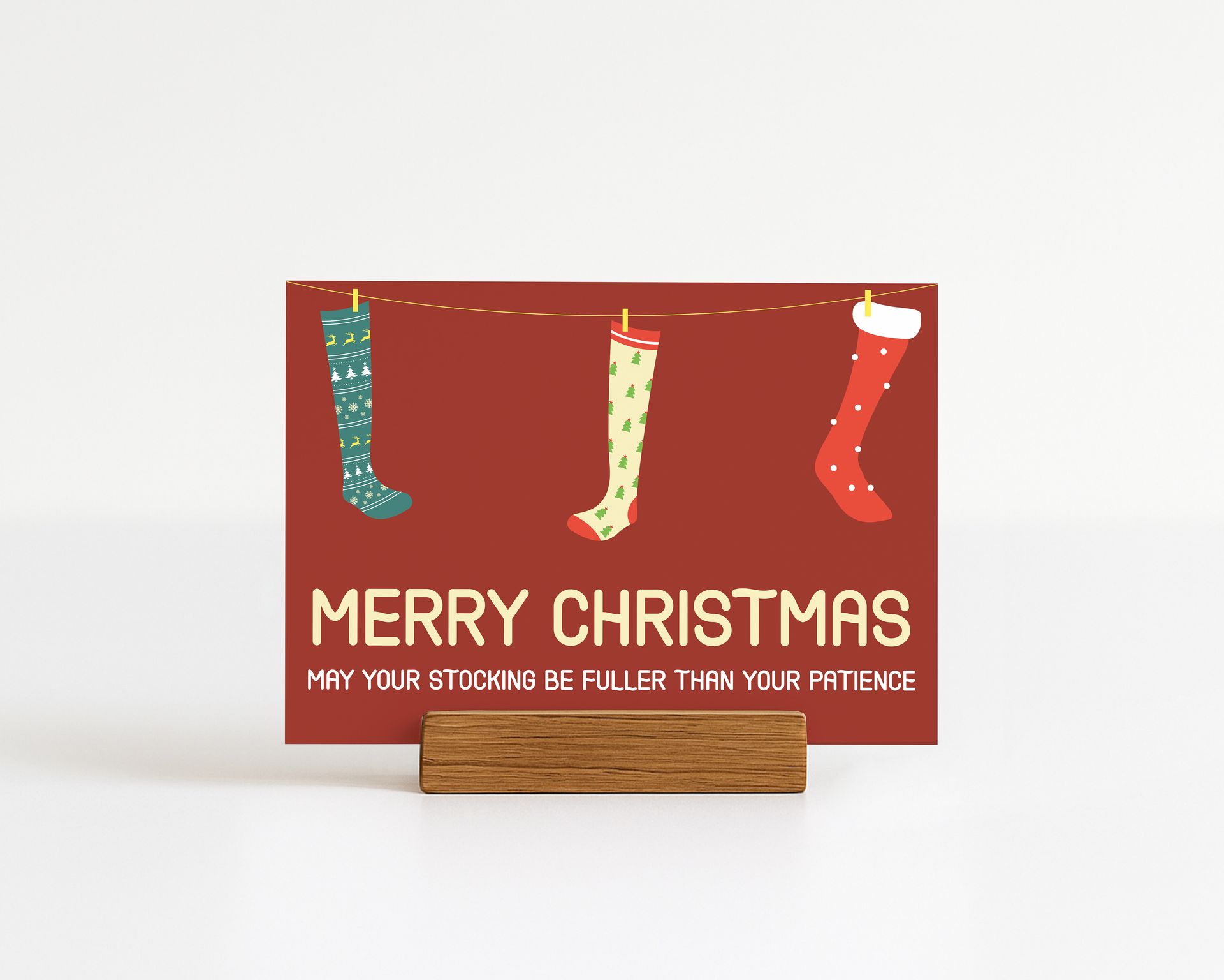 Christmas card with stockings hanging on a clothesline; red background with text "Merry Christmas."