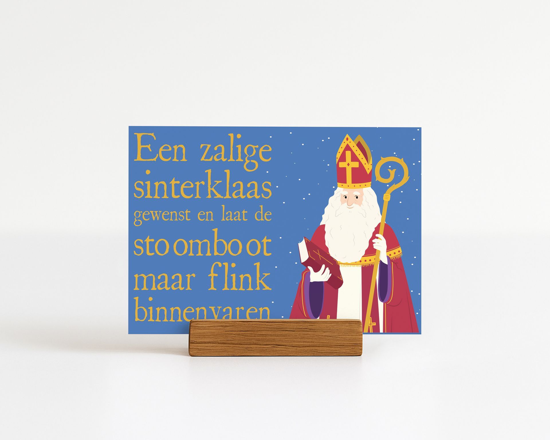 A Sinterklaas card with a wooden stand, featuring a cartoon illustration of Sinterklaas and Dutch text on a blue background.