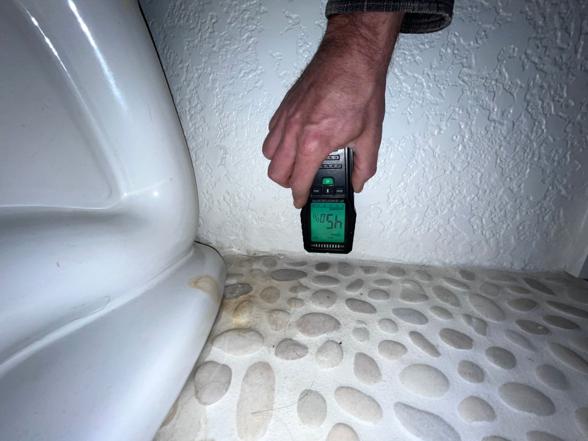 A person is holding a measuring device in their hand.