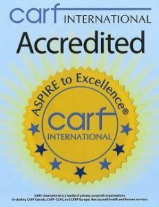 CARF International Accredited gold seal with blue stars and “Aspire to Excellence” text
