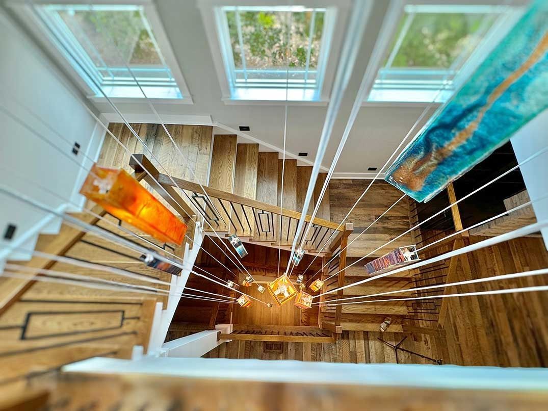 Spiral staircase with warm lights and colorful hanging banners in a bright indoor atrium