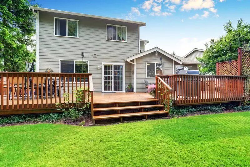 A house with a large wooden deck in the backyard.
